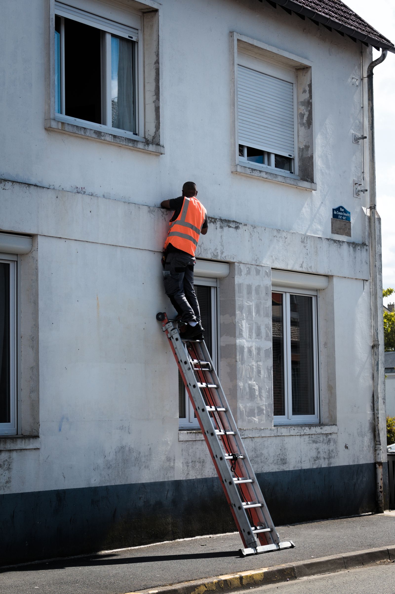 Symbolbild: Person führt eine Wartungsarbeit an einer Gebäudefassade aus