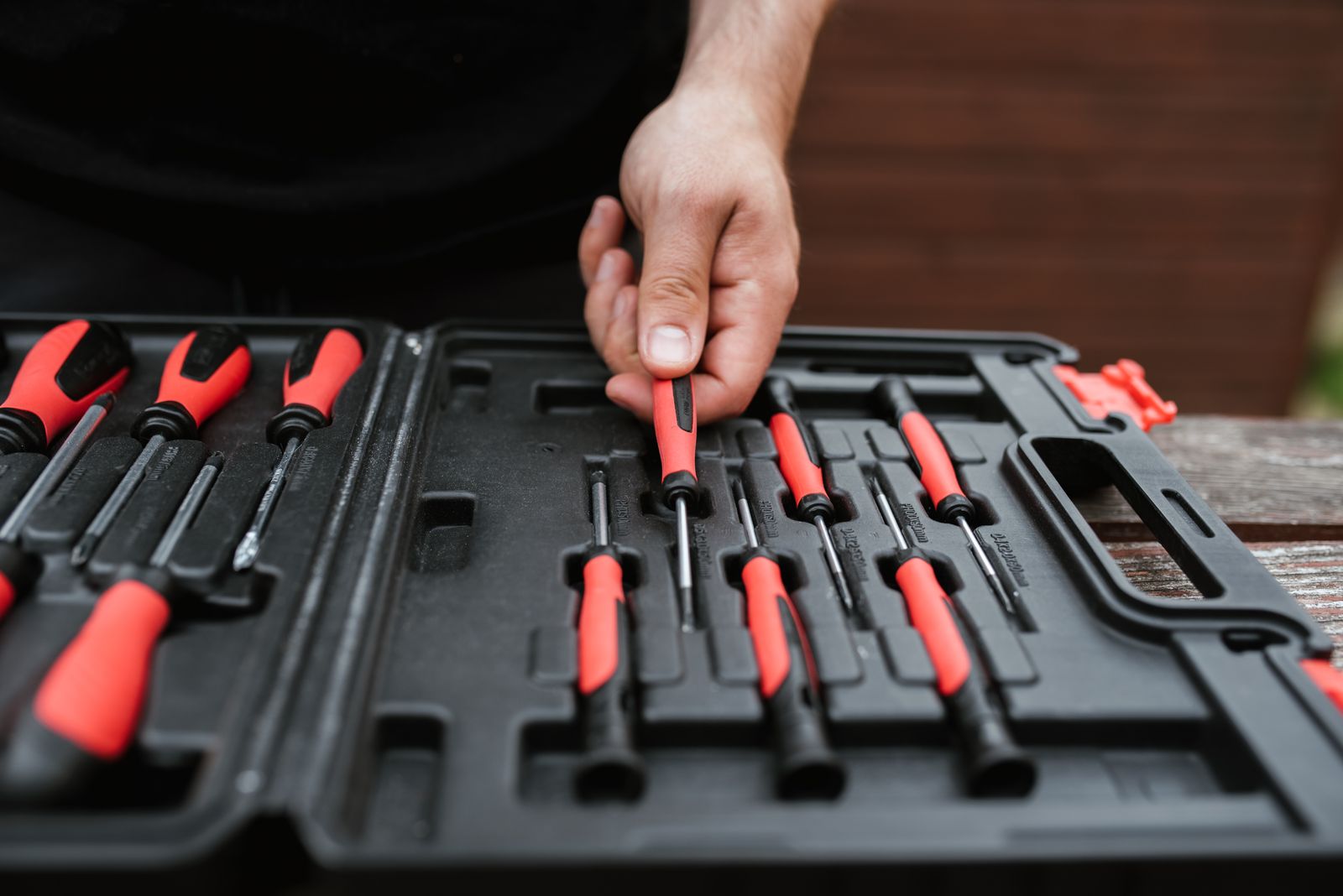Symbolbild: Handwerker wählt einen Schraubendreher aus einem Werkzeugkoffer